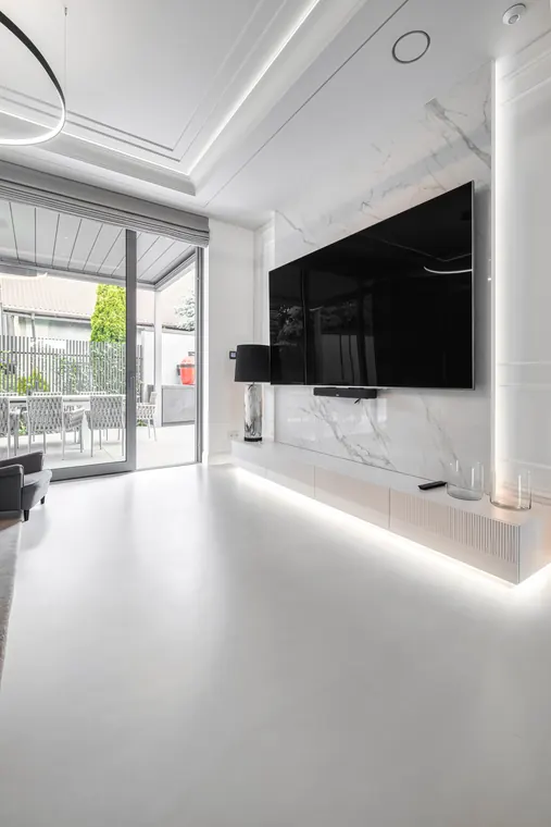 Salon z marmurową ścianą i dużym telewizorem